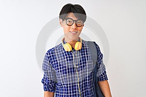 Chinese student man wearing backpack and headphones over isolated white background with a happy and cool smile on face