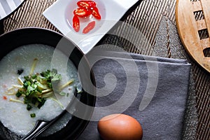 Chinese style porridge or porridge and fried dough stick or fried dough stick or donut or fried bread placed on a brown wooden tab