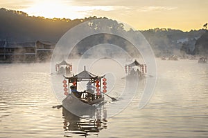 Chinese style tourist boat attraction at Ban Rak Thai village, Mae Hong Son, Thailand during winter morning sunrise with misty fog