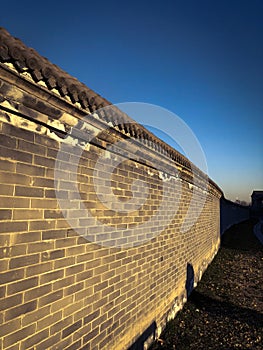 A Chinese-style wall is very historic in the sunset.