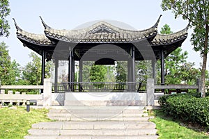 Chinese summer terrace on a hill. The architecture is oriental beautiful style with black round columns. Eastern construction