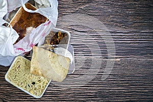Chinese takeaway food selection in plastic bag. Bami, babi pangang, crispy shredded beef, sweet and sour chicken, krupuk
