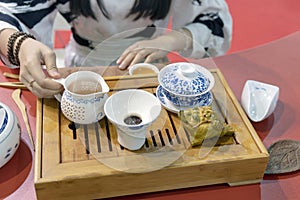 Chinese tea ceremony. Girl pours tea from kettle into cup
