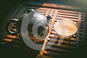 Chinese tea ceremony. Teapot and a cup of green puer tea on wooden table. Asian traditional culture.