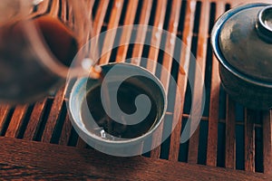 Chinese tea cup is poured by hot fresh black tea