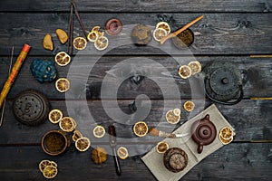 Chinese tea with dry bergamot and different tools and figurines on black table