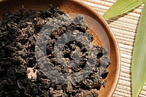 Chinese tea leaves with bamboo on wooden plate