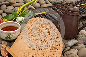 Chinese tea set, abacus, Chinese fan, flowers placed on granite blocks