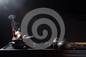 Chinese tea set on a black table with steam.