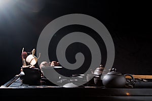 Chinese tea set on a black table with steam. China, tea, tableware, kettle, tradition, health, tea ceremony