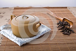 Chinese teapot, spoon and tea leaves
