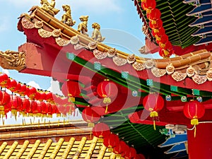 Chinese Temple roof details and Red Lanterns against a blue sky
