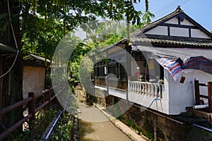 Chinese tile-roofed houses along creek in sunny summer