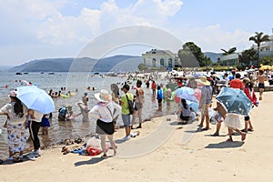 Chinese tourists on a beach of the Fuxian Lake in Yunnan, the thid deepest lake in China. It is located halfwy between the capital