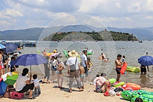 Chinese tourists on a beach of the Fuxian Lake in Yunnan, the thid deepest lake in China. It is located halfwy between the capital