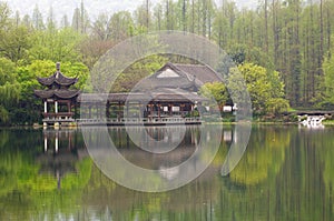 Chinese traditional bridge with pavilion on the coast of West Lake, public park in Hangzhou city, China