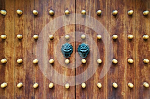 Chinese traditional doorknob and wooden doors. Old handle of metal on a wooden old door. Door knocker in the shape of a