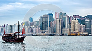 Chinese traditional junk boat in front of Hong Kong skyline