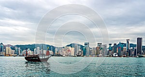 Chinese traditional junk boat in front of Hong Kong skyline