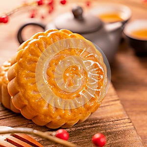 Chinese traditional pastry Moon cake Mooncake with tea cups on bamboo serving tray on wooden background for Mid-Autumn Festival,