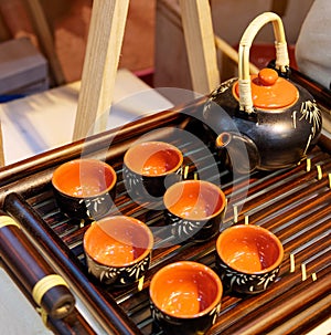 Chinese white teapot and teacups on the wooden trivet