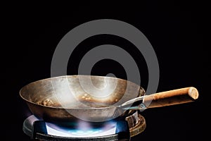 Chinese wok pan on fire gas burner