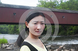 A chinese woman with covered bridge background