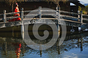 Chinese woman crossing concrete bridge