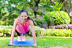 Chinese woman doing push-ups in park