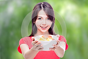 Chinese woman holding bowl of fruit