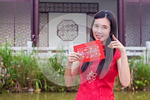 Chinese woman holding red packet happily during chinese new year season