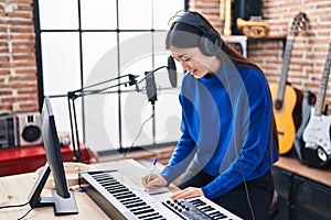 Chinese woman musician composing song at music studio