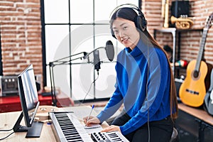 Chinese woman musician composing song at music studio