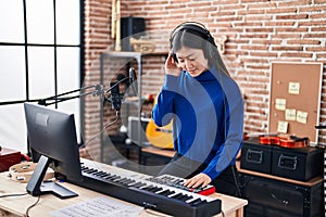 Chinese woman musician having dj session at music studio