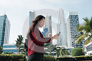 Chinese Woman With Phone Walking And Drinking Coffee