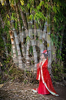 Chinese woman posing near giant bamboo