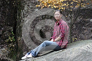 Chinese woman sat on rock