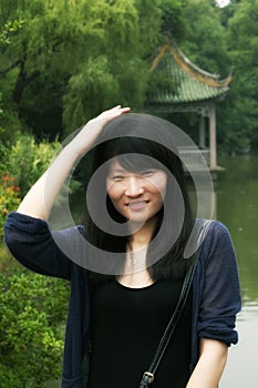 Chinese woman smiling and patting her head