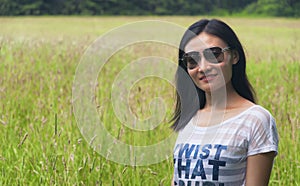 Chinese woman standing in a field of tall grass