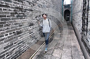 A chinese woman standing in narrow alley