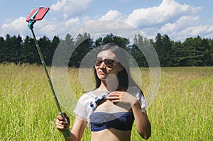 Chinese woman taking a selfie outside near a meadow