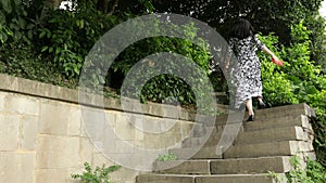 Chinese woman talking on a cell and very angry outdoors on a stone stairways