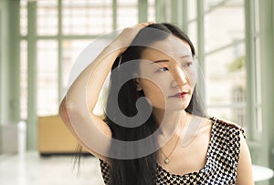 chinese woman thinking and sitting in a room photo