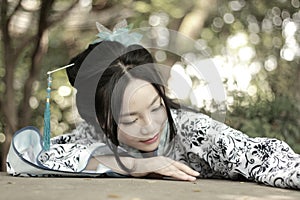 Chinese woman in traditional Blue and white Hanfu dress Climb over the stone table