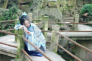 Chinese woman in traditional Blue and white Hanfu dress Climb on the railing