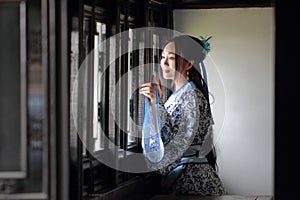 Chinese woman in traditional Blue and white Hanfu dress Stand behind the window