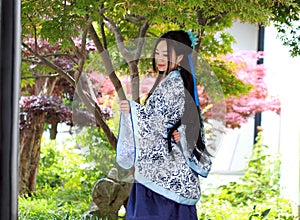 Chinese woman in traditional Blue and white Hanfu dress Stand under the maple tree