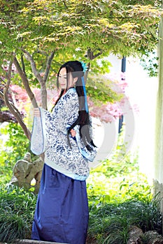 Chinese woman in traditional Blue and white Hanfu dress Stand under the maple tree