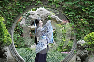 Chinese woman in traditional Blue and white Hanfu dress Standing in the middle of beautiful gate