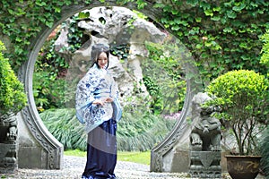 Chinese woman in traditional Blue and white Hanfu dress Standing in the middle of beautiful gate